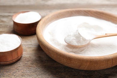 Dishware with baking soda on wooden table