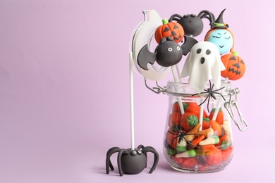 Delicious Halloween themed cake pops on pink background, space for text