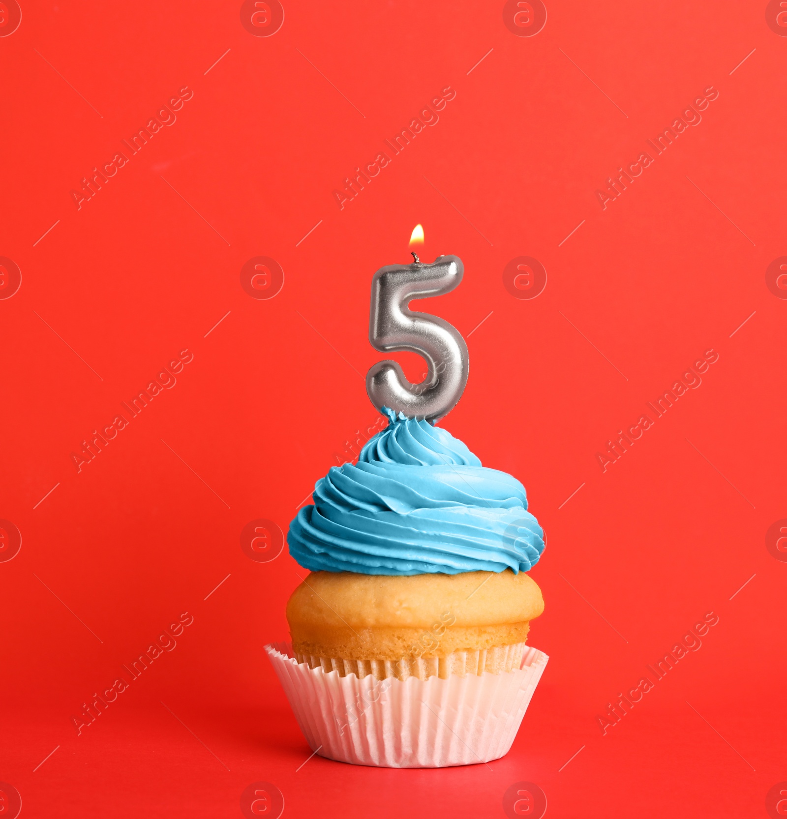 Photo of Birthday cupcake with number five candle on red background