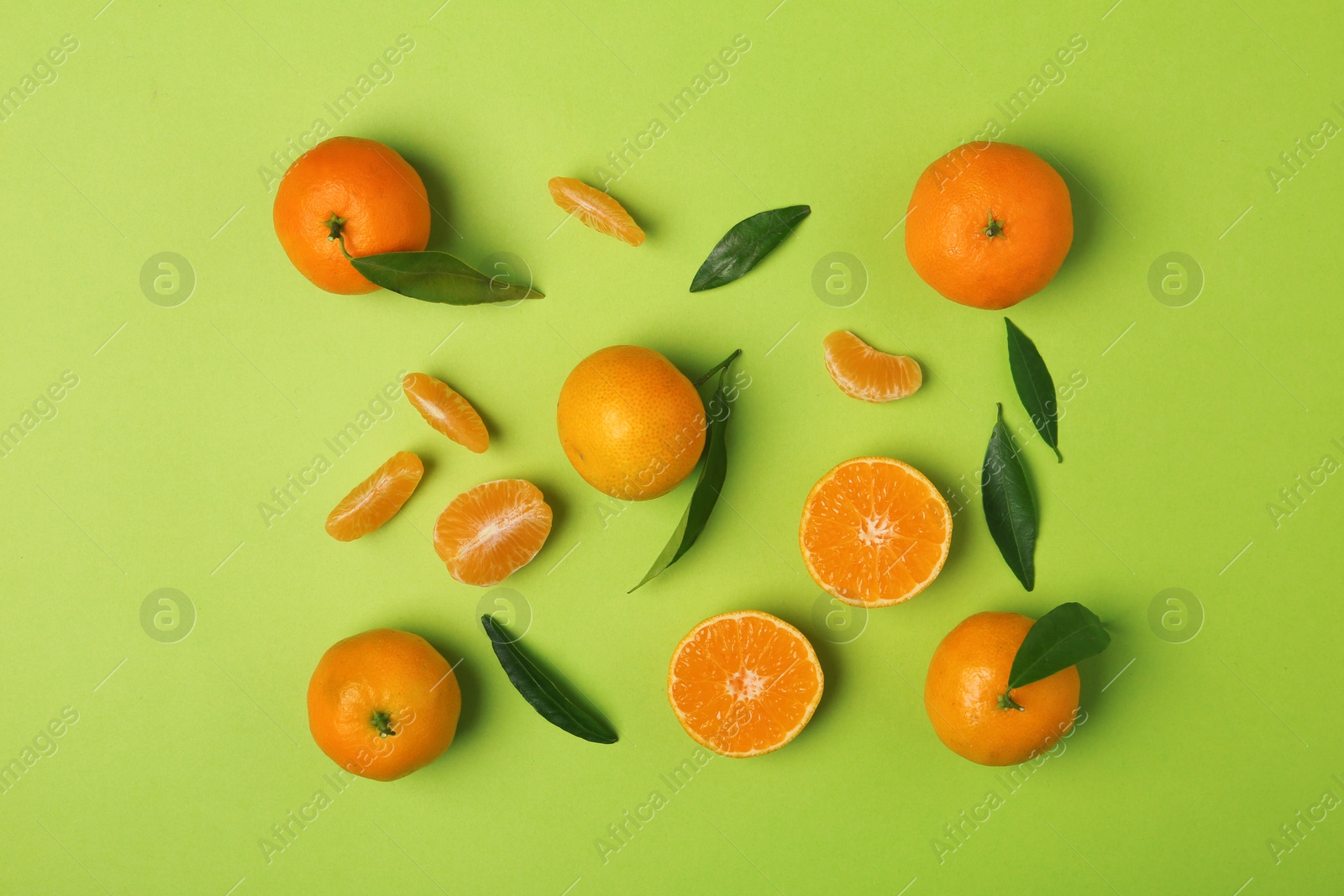 Photo of Composition with tangerines and leaves on color background, flat lay