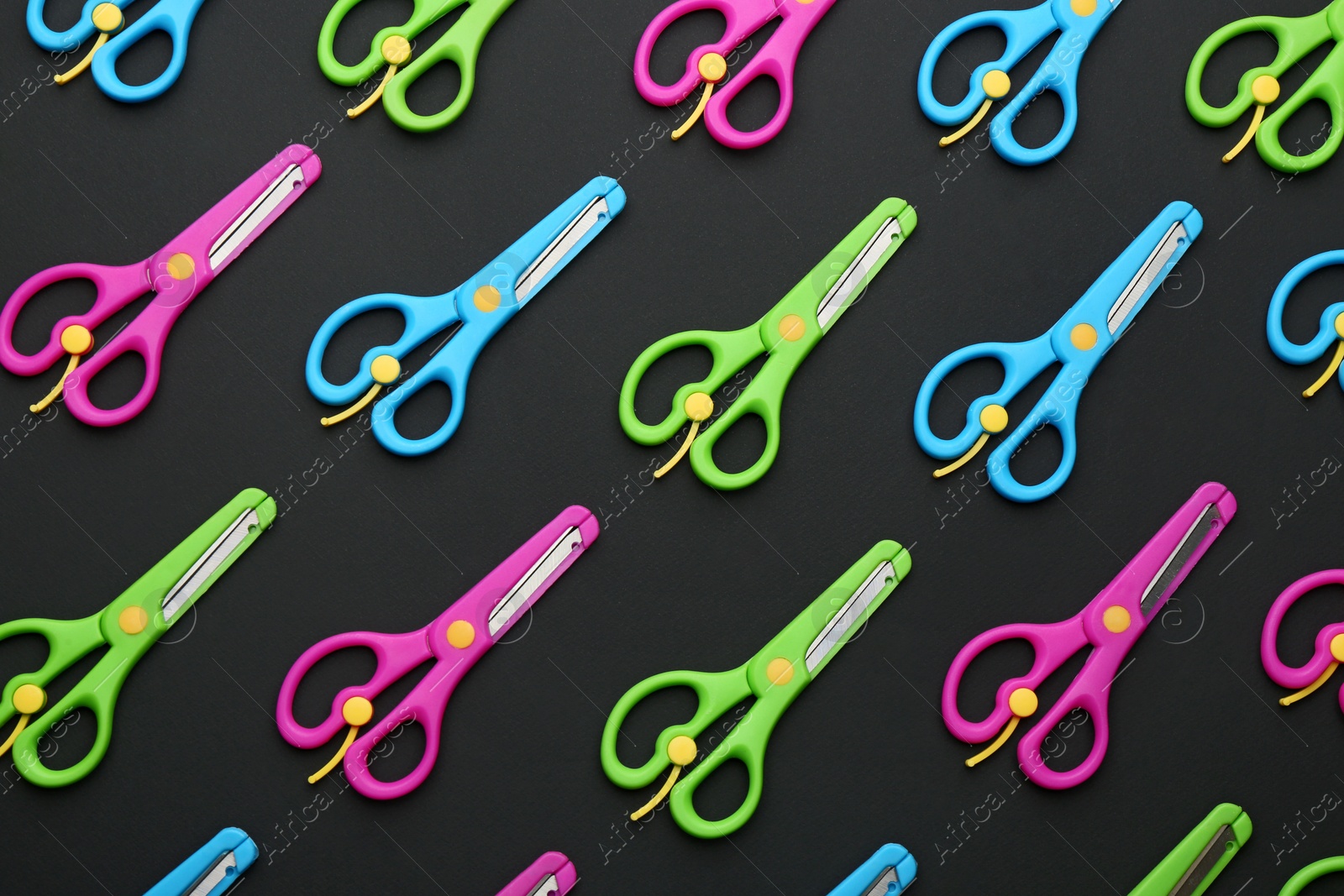 Photo of Set of training scissors on dark background, flat lay