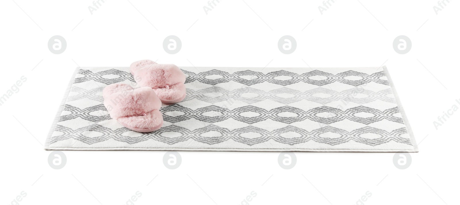 Photo of New bath mat with fluffy slippers isolated on white
