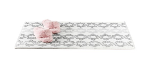 Photo of New bath mat with fluffy slippers isolated on white