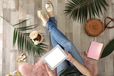 Photo of Woman with tablet sitting on floor, top view. Fashion blogger