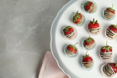 Photo of Dessert stand with chocolate covered strawberries on grey background, top view