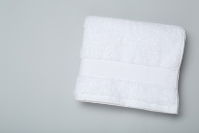 Photo of White terry towel on light grey background, top view. Space for text