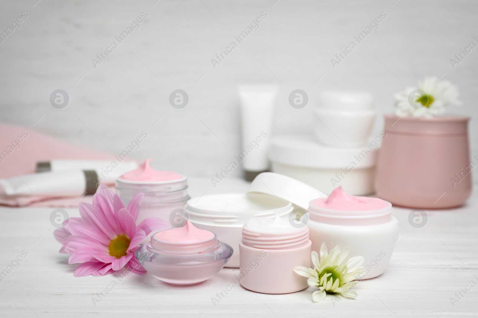 Photo of Composition with body cream in jars on light background