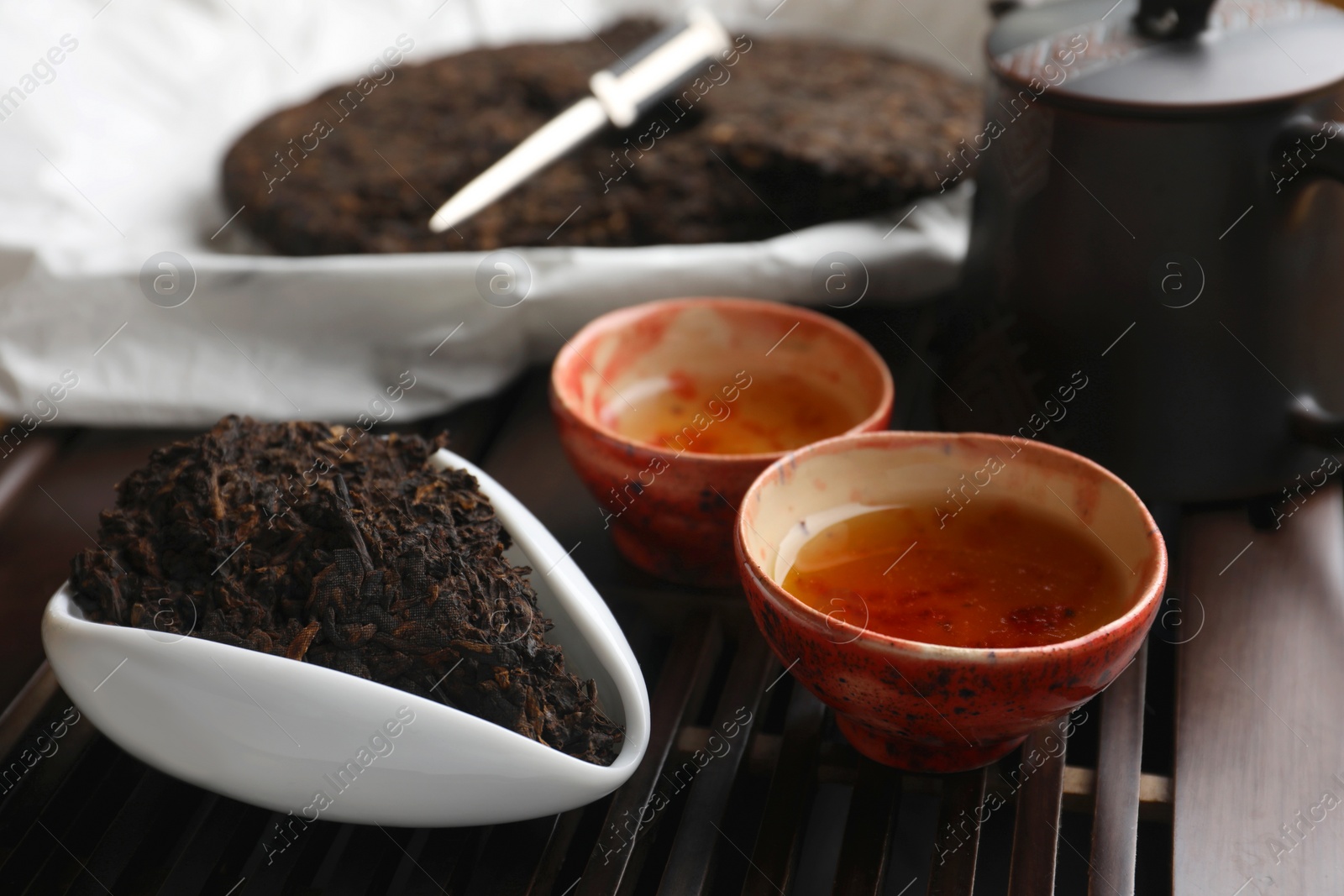 Photo of Aromatic pu-erh on wooden tray, closeup. Fermented tea