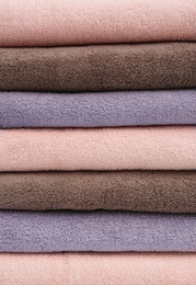 Stack of folded soft colorful towels as background