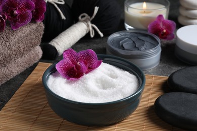 Photo of Beautiful composition with sea salt, burning candle, flowers and different spa products on grey table