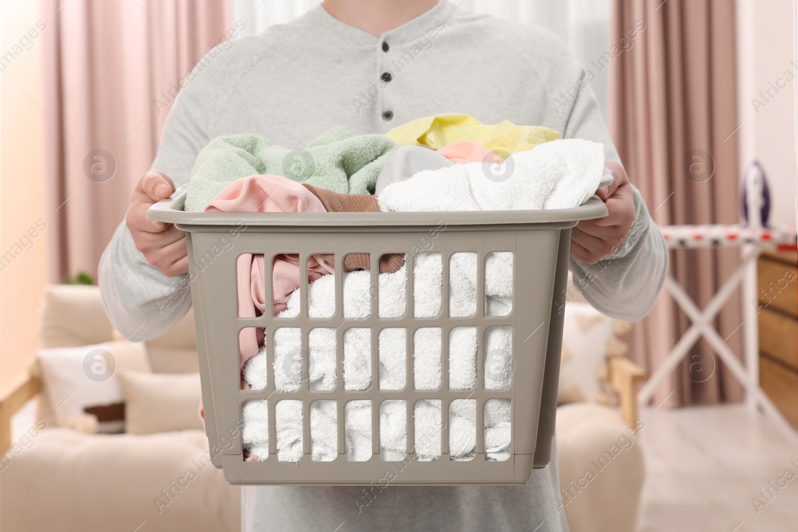 Photo of Man with basket full of laundry at home, closeup