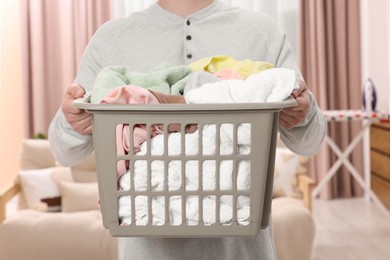 Photo of Man with basket full of laundry at home, closeup