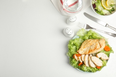Photo of Tasty cooked chicken fillet with fresh salad  and space for text on white table, flat lay. Healthy meals from air fryer