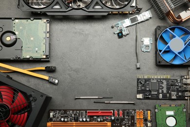 Photo of Frame of graphics card and other computer hardware on grey textured table, flat lay. Space for text