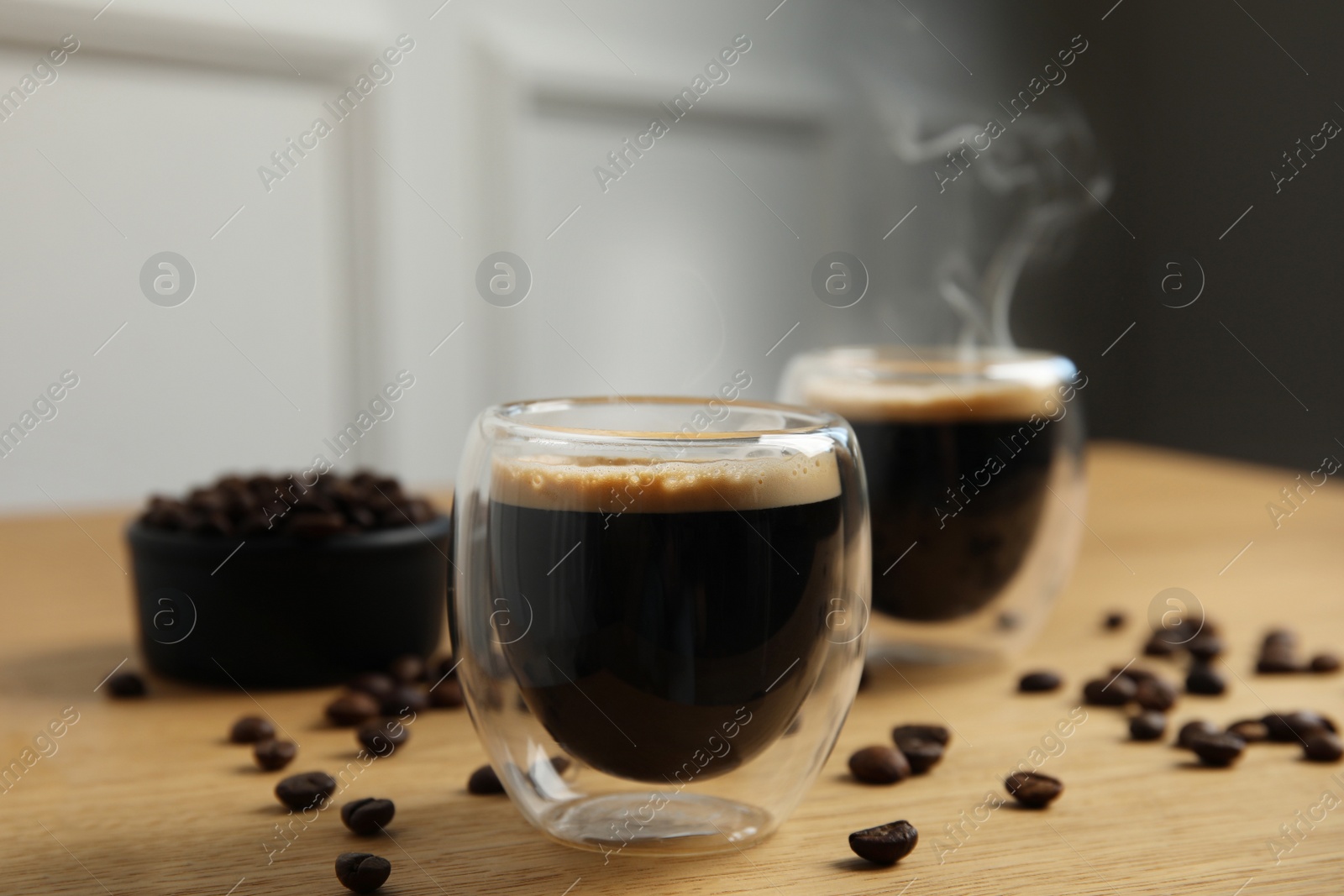 Photo of Tasty coffee and beans on wooden table indoors