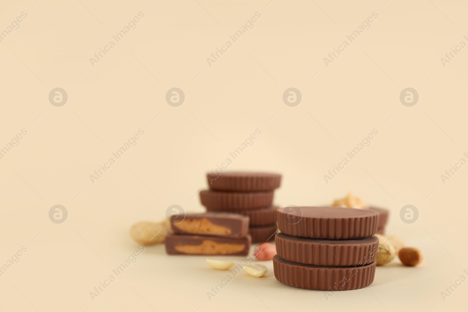 Photo of Sweet peanut butter cups on beige background. Space for text