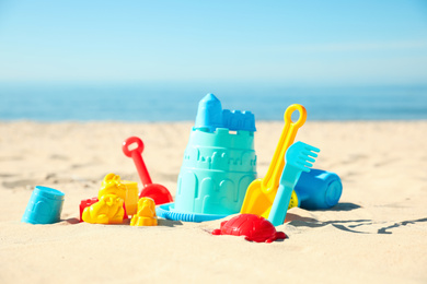 Different child plastic toys on sandy beach