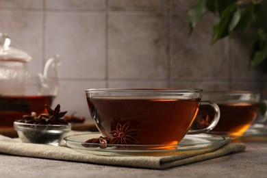 Aromatic tea with anise stars on light grey table