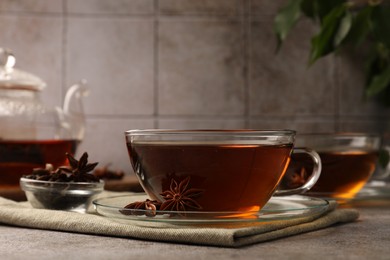 Photo of Aromatic tea with anise stars on light grey table