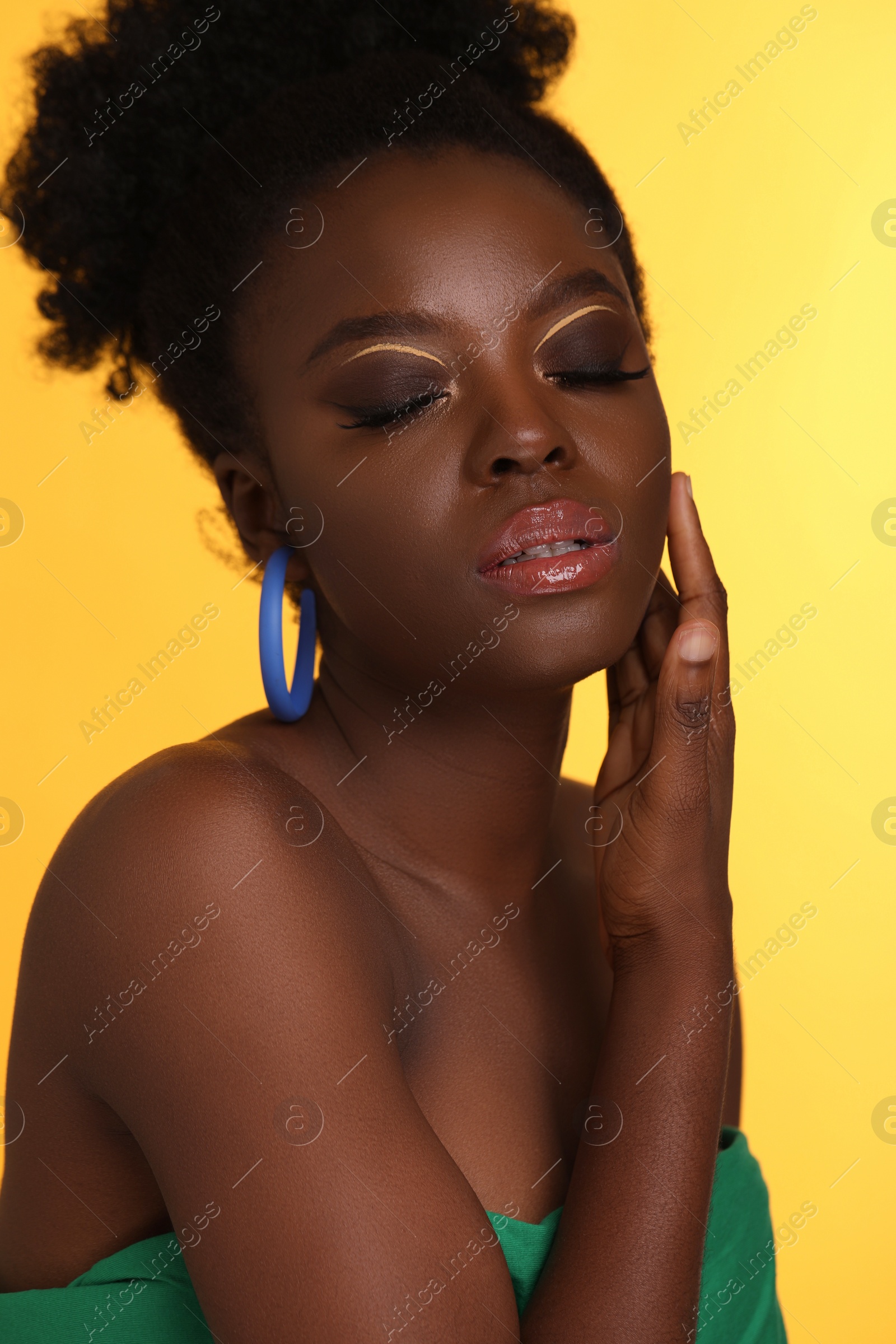 Photo of Fashionable portrait of beautiful woman with makeup on yellow background