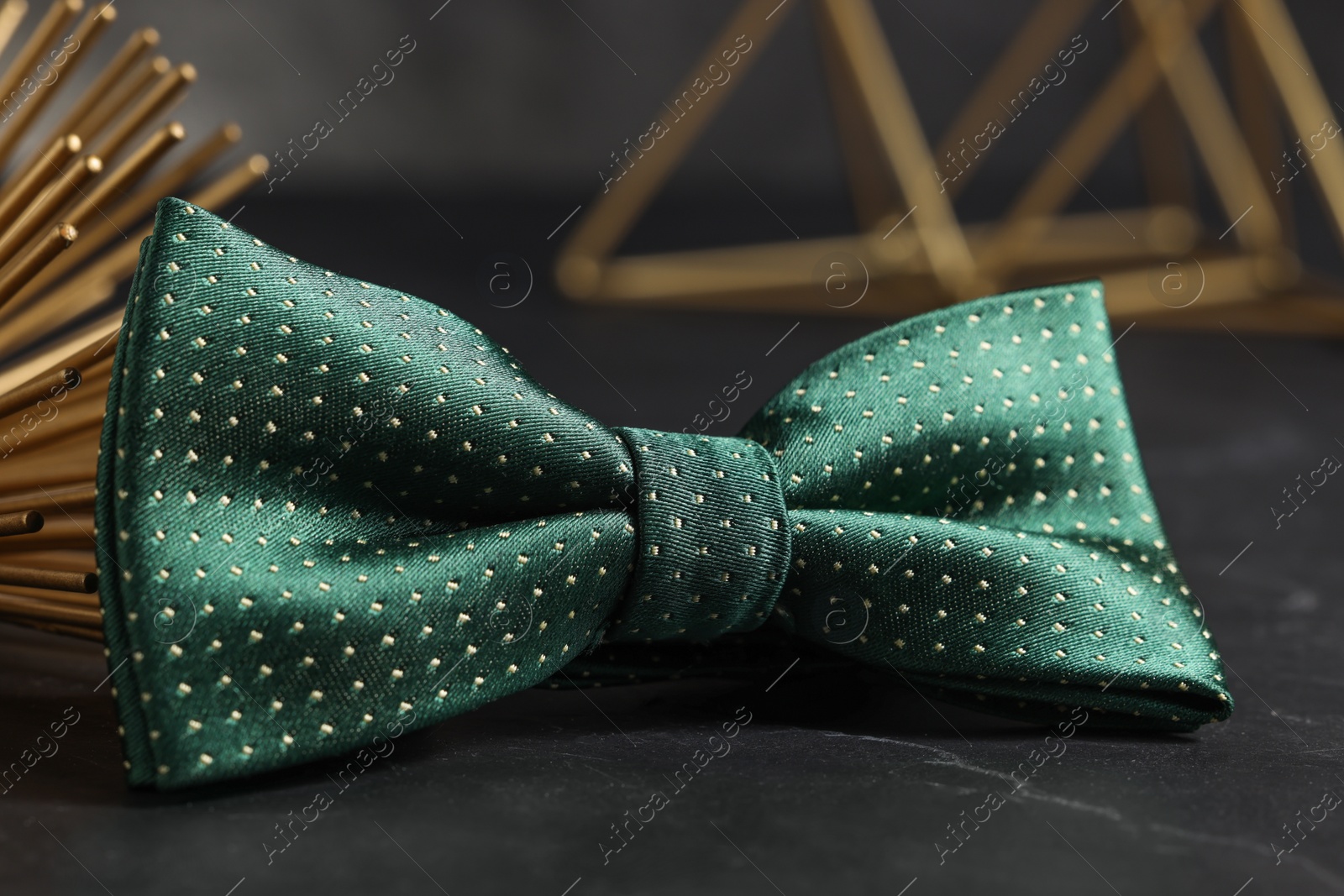 Photo of Stylish green bow tie on black table, closeup