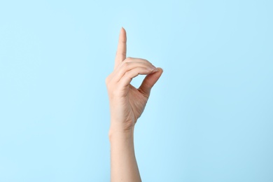 Photo of Woman showing D letter on color background, closeup. Sign language