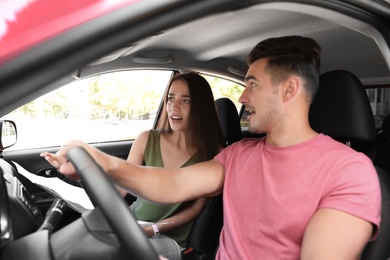 Young couple with map in car on road trip