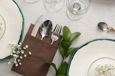 Photo of Elegant table setting with green plants on white wooden background, flat lay