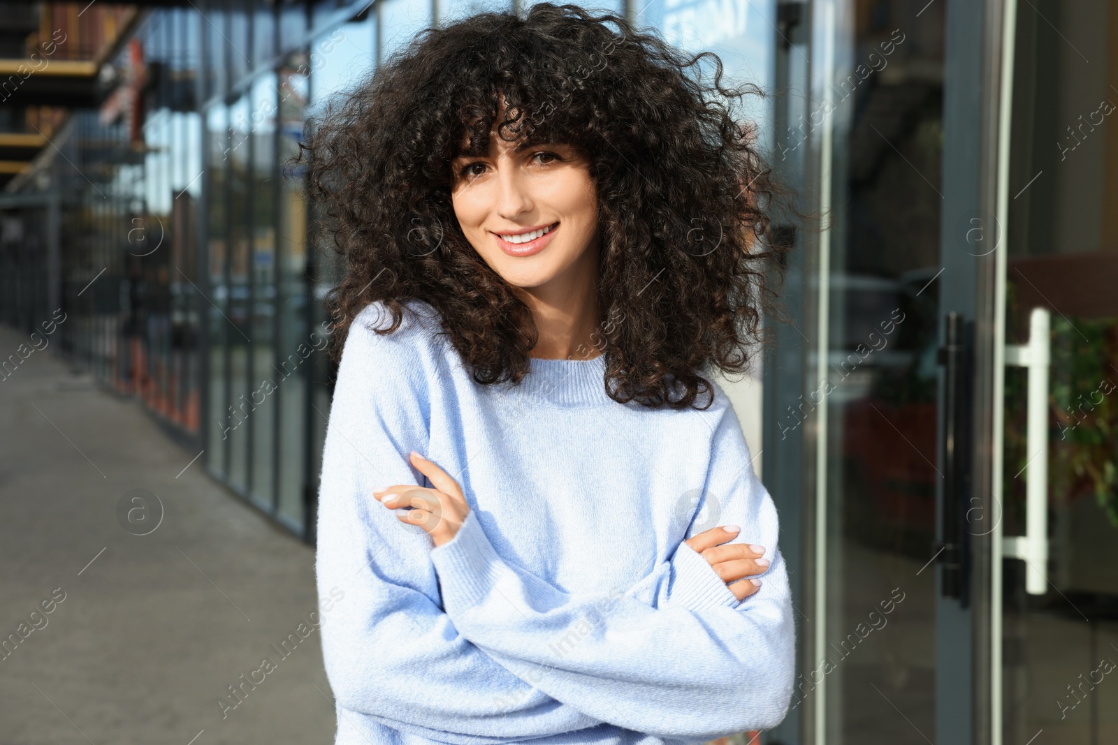 Photo of Happy young woman in stylish light blue sweater outdoors