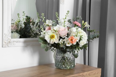 Bouquet with beautiful flowers on wooden chest of drawers indoors
