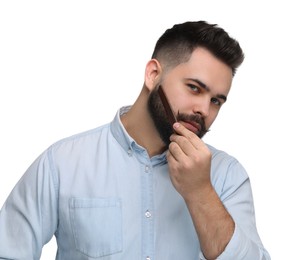 Handsome young man combing beard on white background