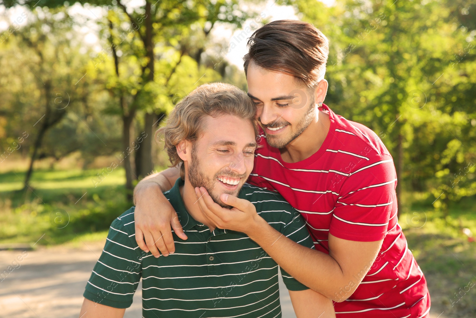 Photo of Portrait of happy gay couple smiling in park