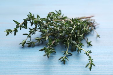 Bunch of fresh thyme on light blue wooden table, closeup