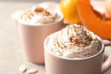 Photo of Cup with tasty pumpkin spice latte on gray table, closeup