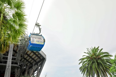 Photo of BATUMI, GEORGIA - MAY 31, 2022: Cableway with cabin against cloudy sky, low angle view