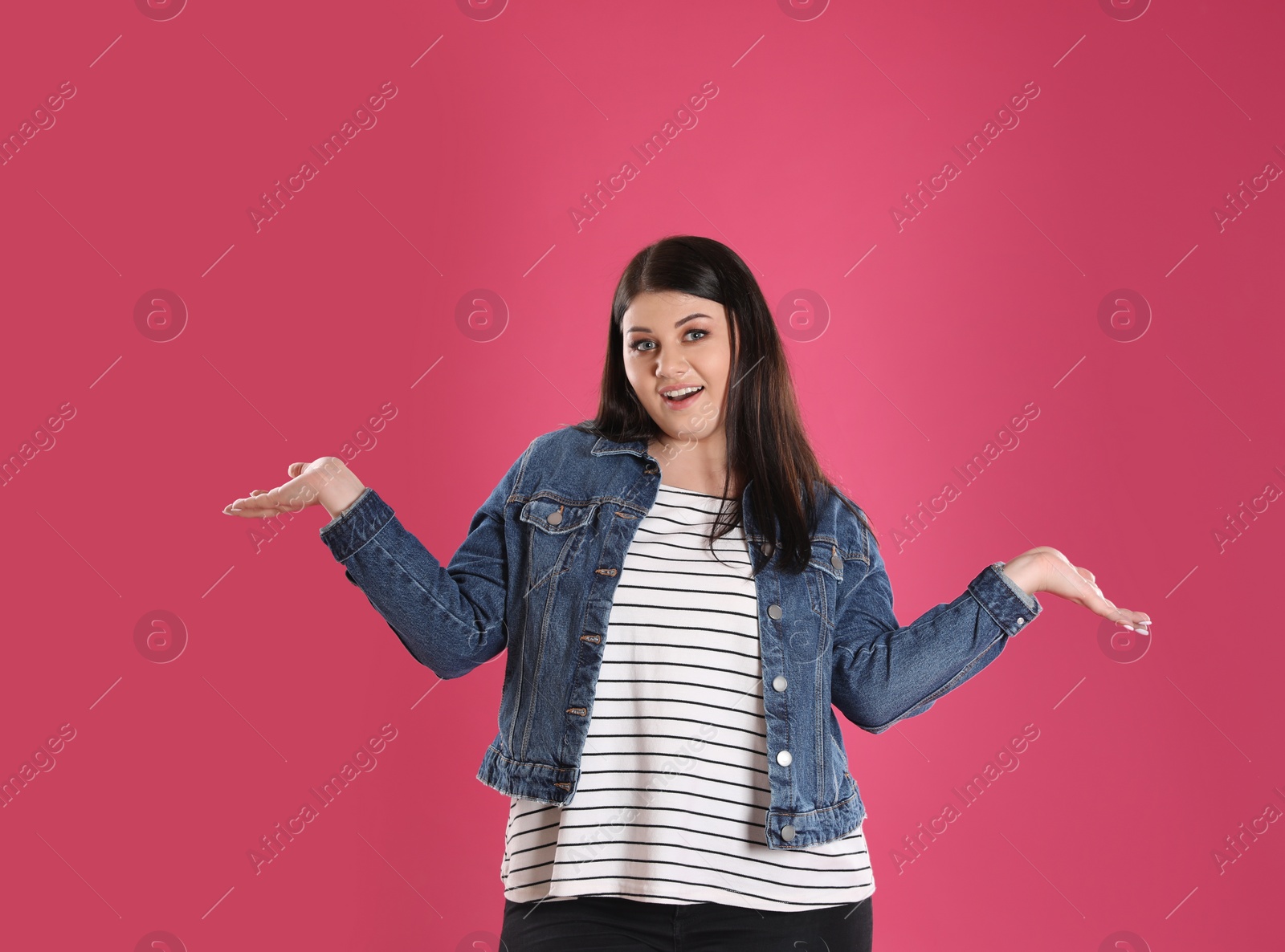 Photo of Beautiful overweight woman posing on pink background. Plus size model