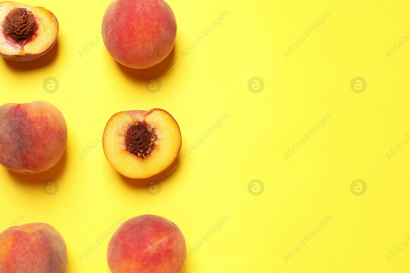 Photo of Delicious juicy peaches on yellow background, flat lay. Space for text