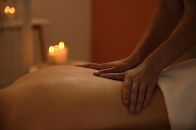 Young woman receiving back massage in spa salon, closeup