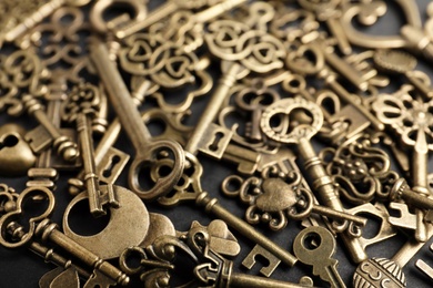 Photo of Bronze vintage ornate keys on dark background, closeup