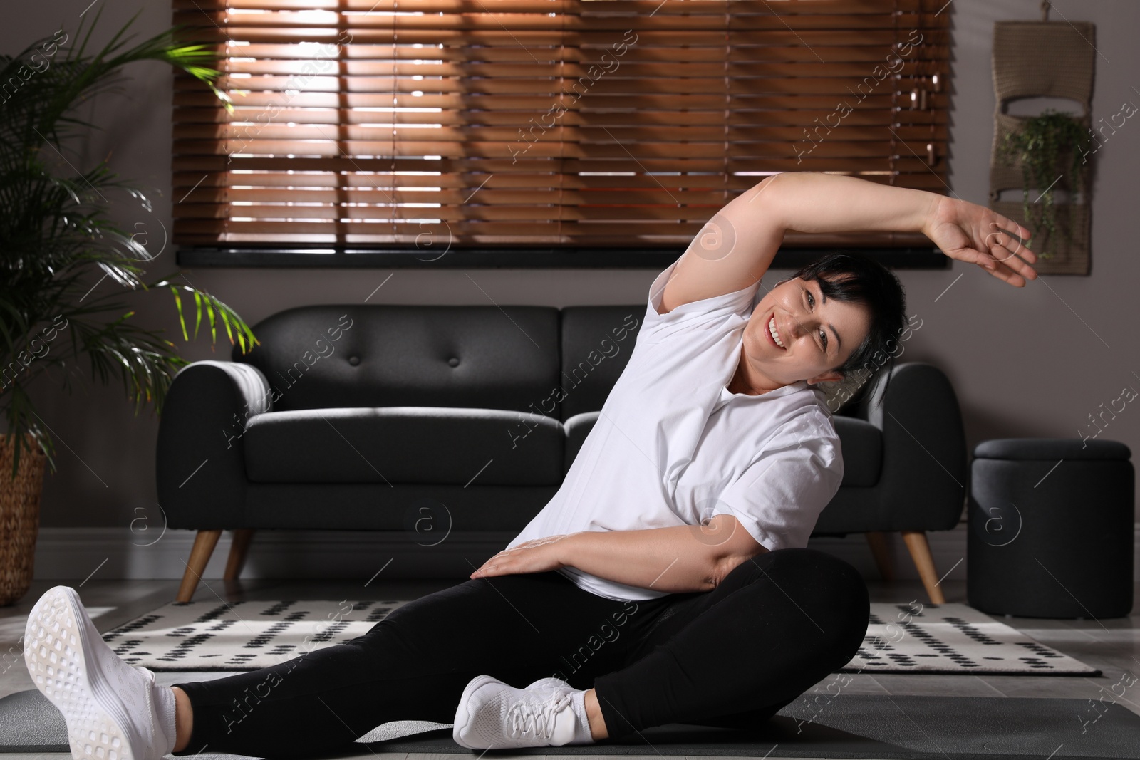 Photo of Overweight mature woman doing exercise at home