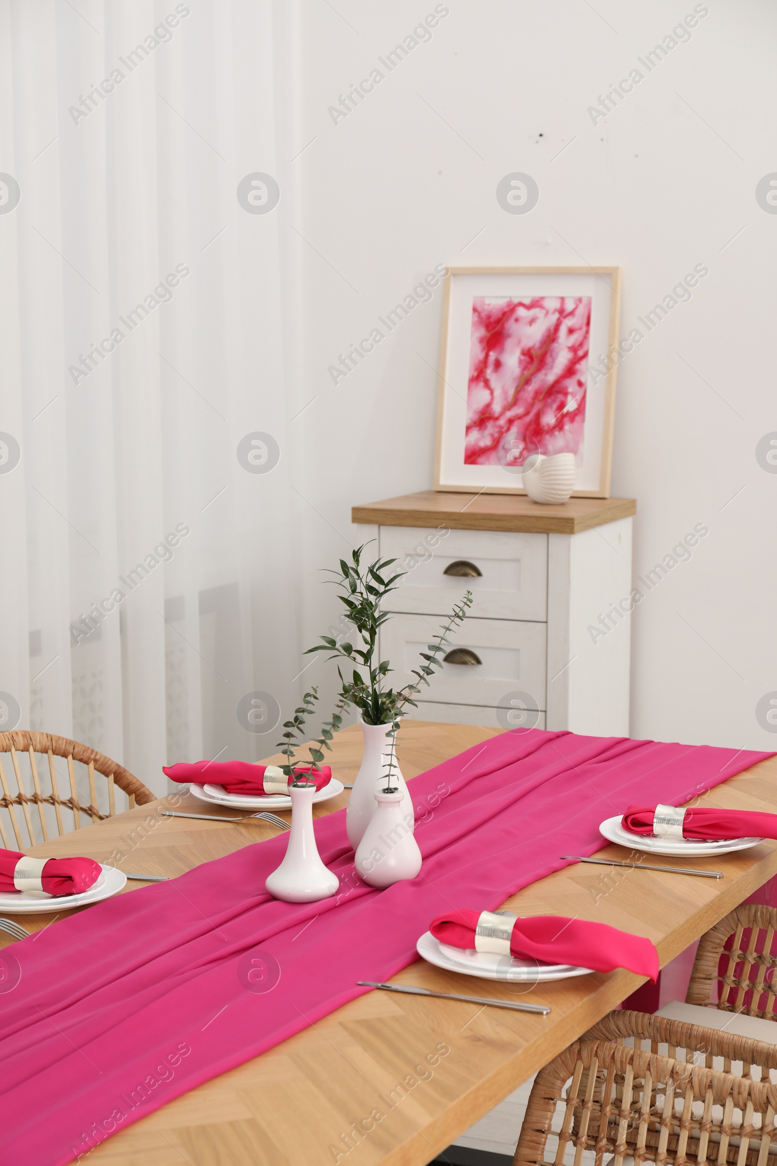 Photo of Beautiful table setting and vases with green branches in dining room