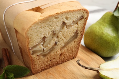 Photo of Tasty pear bread on wooden board, closeup. Homemade cake