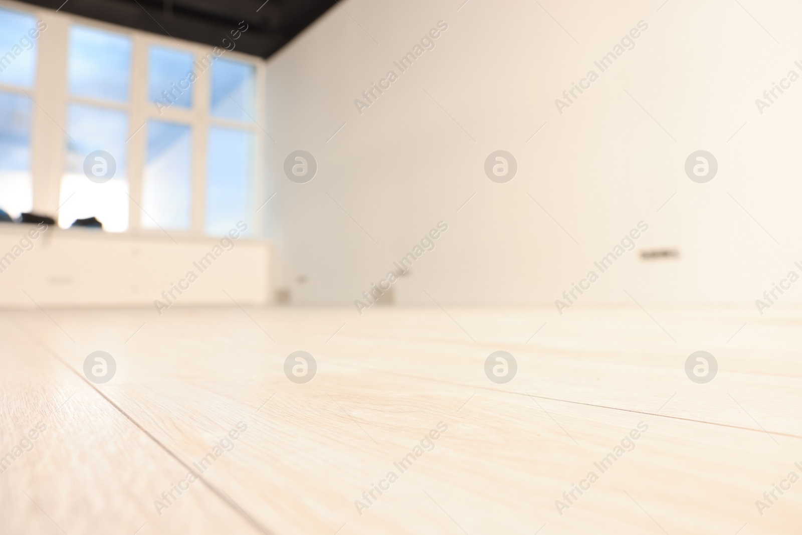 Photo of Empty room with new white laminated flooring, closeup