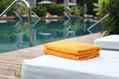 Sun loungers near outdoor swimming pool at luxury resort