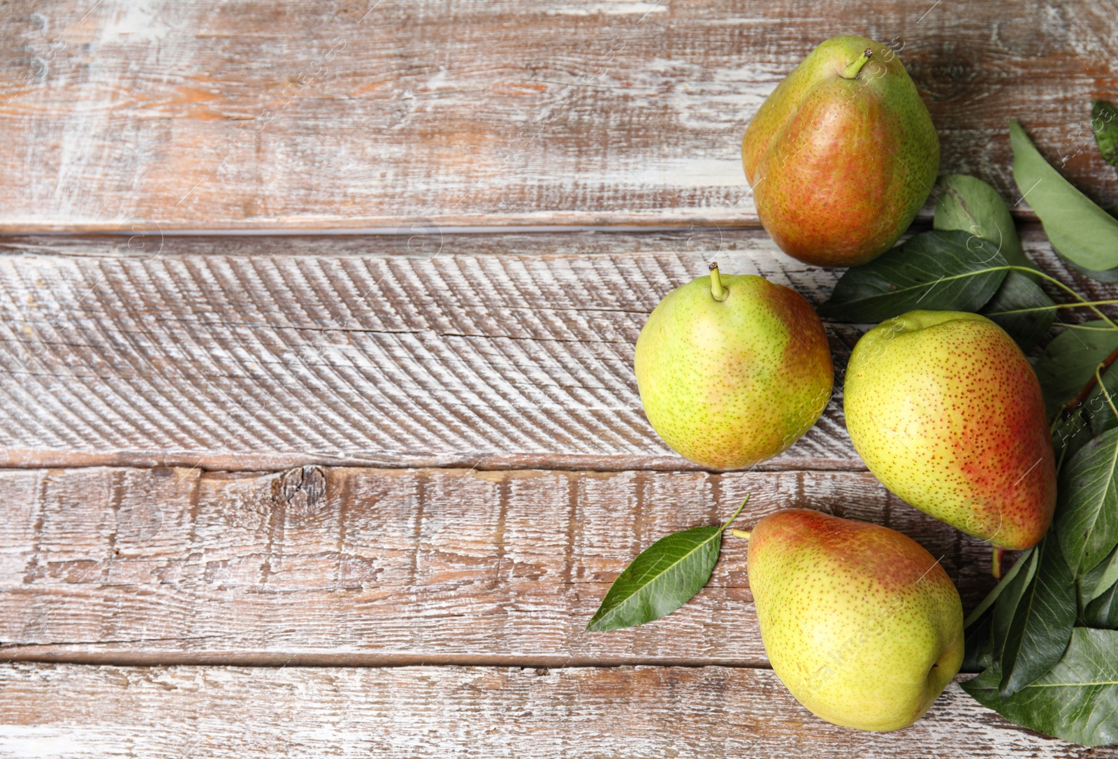 Photo of Ripe juicy pears on brown wooden table, flat lay. Space for text