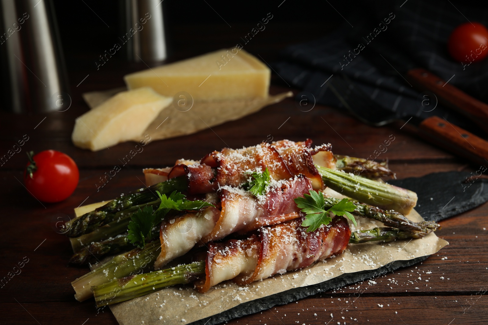 Photo of Oven baked asparagus wrapped with bacon on wooden table