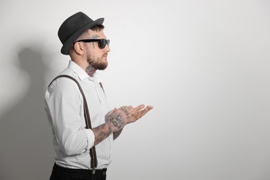 Photo of Handsome hipster man wearing stylish sunglasses on light grey background. Space for text