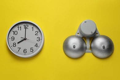Modern electrical school bell and clock on yellow wall