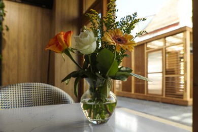 Photo of Bouquet of beautiful flowers on table indoors