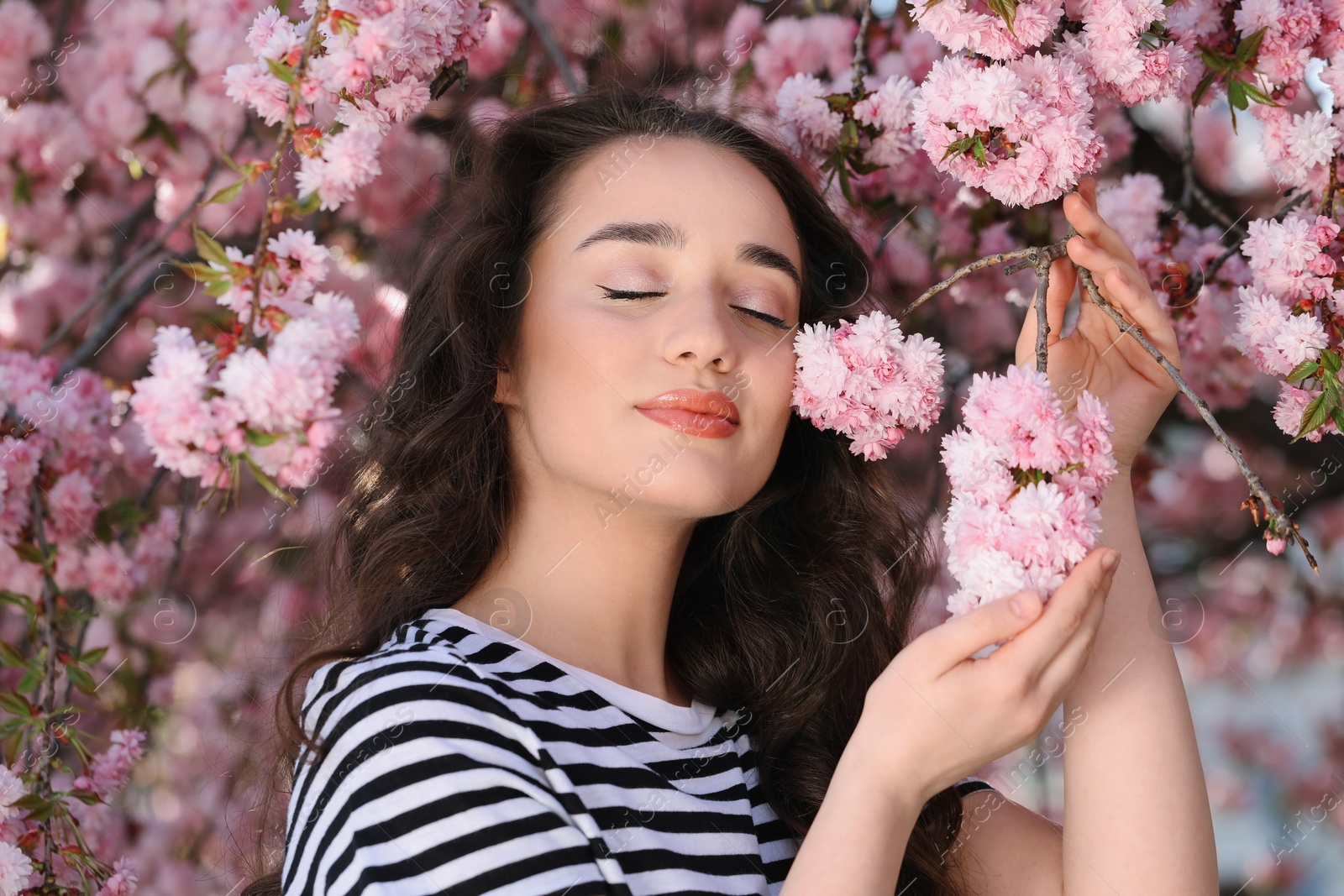 Photo of Beautiful woman near blossoming sakura tree on spring day